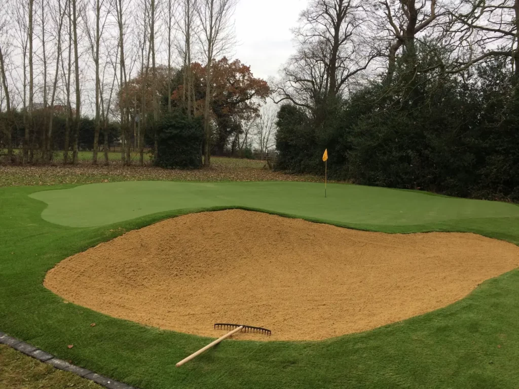 Putting green installation with sand bunker